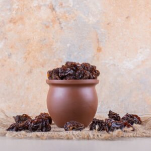 bowl of dry plum fruits placed on white background