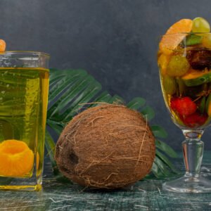 glass of mixed fruits, juice and coconut on marble table