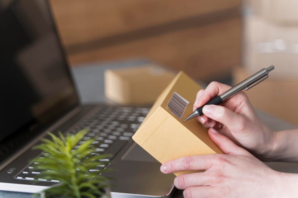 side view woman writing box with laptop plant